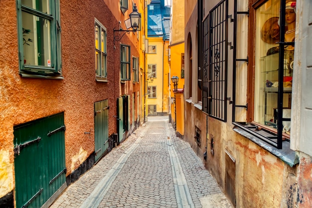 La stretta strada di ciottoli con case medievali di Gamla Stan centro storico di Stoccolma al giorno di sole estivo.