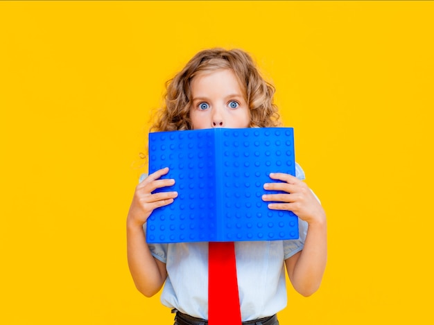 La studentessa spaventata si coprì il viso con un libro blu. studentessa con libro vicino al viso