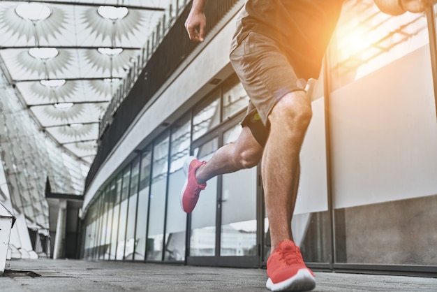 La sua migliore velocità. Primo piano di un giovane in abbigliamento sportivo che corre