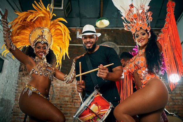 La sua musica è la nostra motivazione Ritratto ritagliato di due bellissime ballerine di samba che si esibiscono in un carnevale con la loro band
