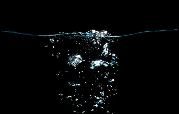 La superficie dell'acqua con increspature e bolle galleggia su sfondo nero