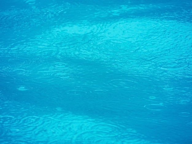 La superficie della piscina e l'acqua si espandono con effetto increspatura sullo sfondo.