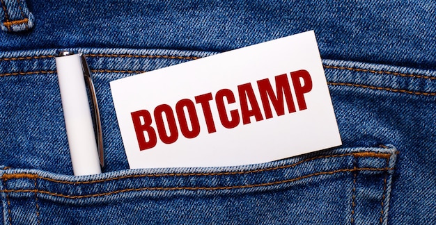 La tasca posteriore dei blue jeans contiene una penna bianca e una carta bianca con il testo BOOTCAMP