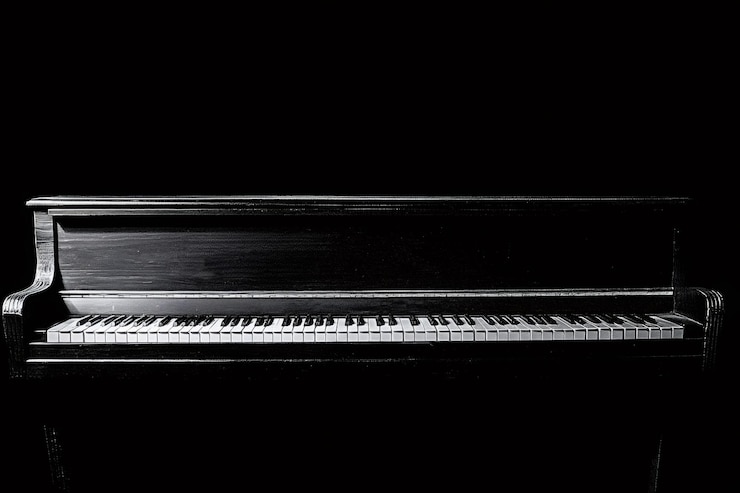 Foto la tastiera classica del pianoforte brilla in bianco e nero su uno sfondo scuro