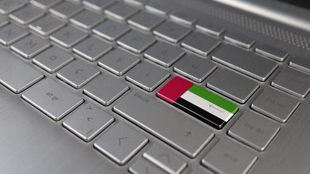 La tastiera con la bandiera degli Emirati Arabi Uniti sul pulsante enter rappresenta il linguaggio di apprendimento degli attacchi informatici