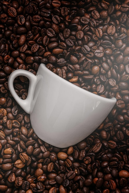 La tazza di caffè bianco si trova in chicchi di caffè tostati di altissimo livello