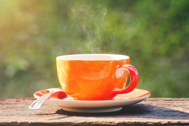 La tazza di caffè calda rinfresca la mattina su fondo verde naturale