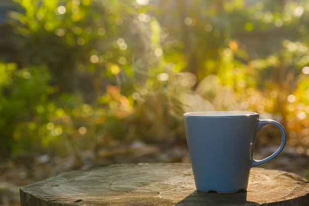 La tazza di caffè con fumo ha messo sul ceppo con lo spazio della copia