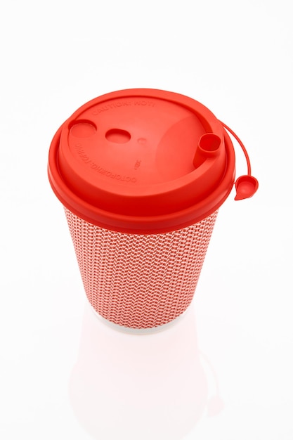 La tazza di caffè di cartone rosa con un coperchio di plastica rossa sullo sfondo bianco lucido l'iscrizione