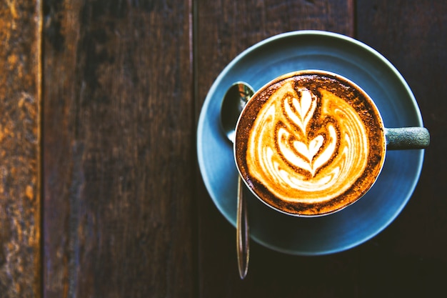 La tazza di cappuccino caldo è sul tavolo di legno