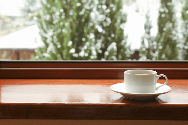 La tazza di tè sta sul davanzale di legno