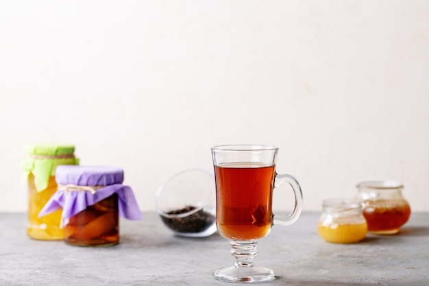 La tazza di vetro di tè nero è servito con miele