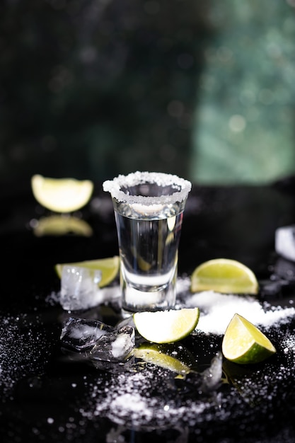 La tequila ha sparato con calce e sale su fondo nero