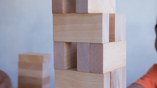 La torre dai blocchi di legno con gioco di pile di gioco del bambino del capretto