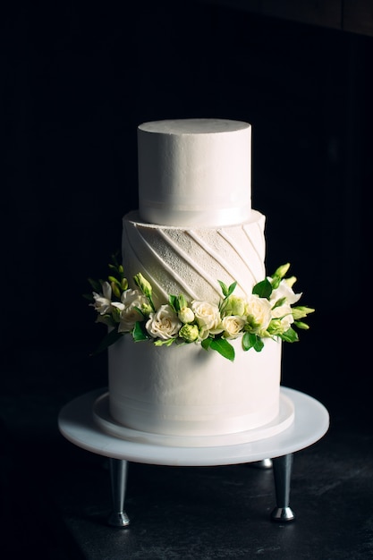 La torta è decorata con fiori sul buio