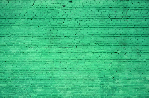 La trama del muro di mattoni di molte file di mattoni dipinti in colore verde