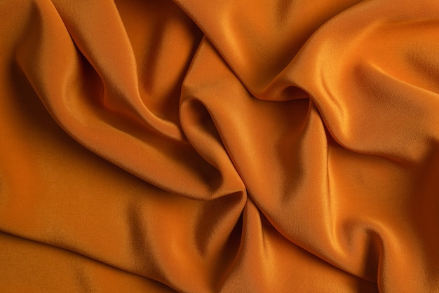 La trama del tessuto di lusso in seta dorata o satinata può essere utilizzata come superficie astratta. Vista dall'alto.