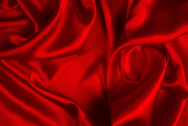 La trama del tessuto di lusso in seta rossa o satinata può essere utilizzata come sfondo astratto. Vista dall'alto.