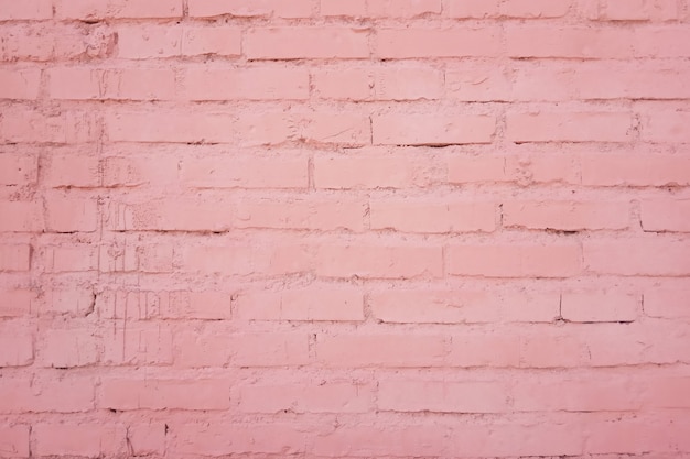 La trama della facciata dell'edificio di un muro di mattoni da file di mattoni dipinti in colore rosa