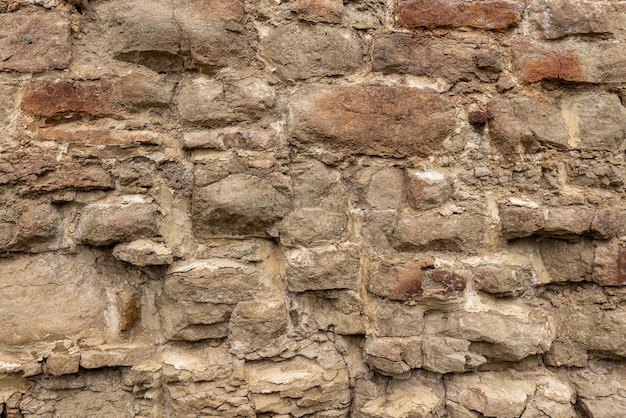 La trama della muratura di pietra bianca vecchia di varie forme con cuciture