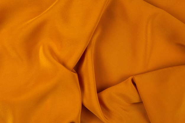 La trama dorata del tessuto di lusso in raso o seta può essere utilizzata come sfondo astratto.