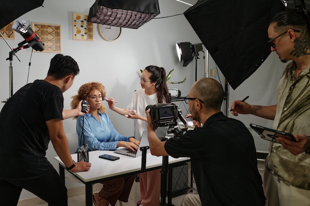 La troupe che lavora con la modella nello studio di produzione