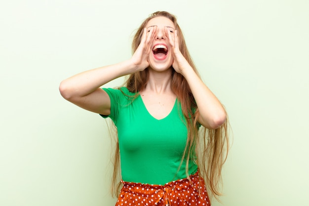 La tua donna bionda si sente felice, eccitata e positiva, lanciando un grande grido con le mani vicino alla bocca, chiamando