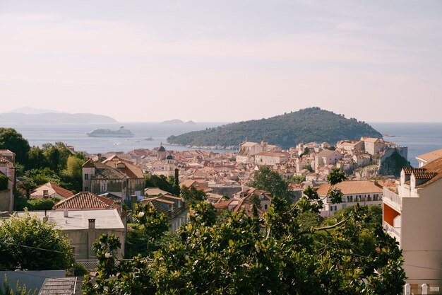 La vecchia città di dubrovnik sullo sfondo dell'isola di lokrum e una nave da crociera all'alba