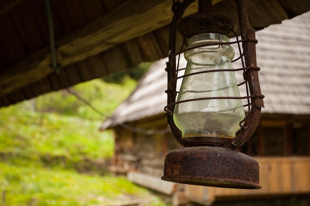 La vecchia luce è quasi arrugginita, ma molto particolare ed è appesa a una casa di legno.