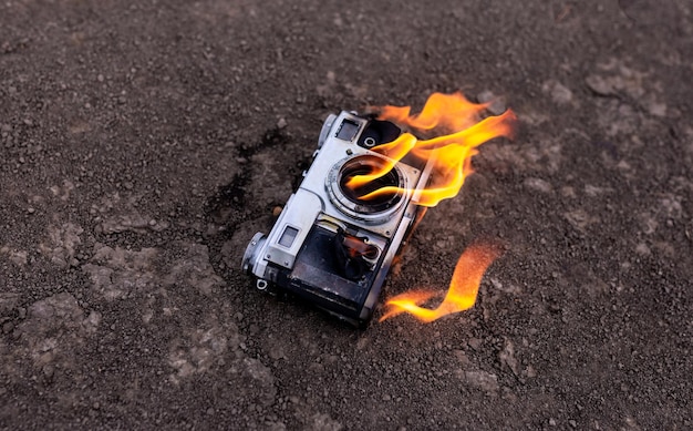 La vecchia macchina fotografica è in fiamme. Concetto per il fotografo.