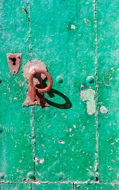 La vecchia maniglia di legno verde della porta