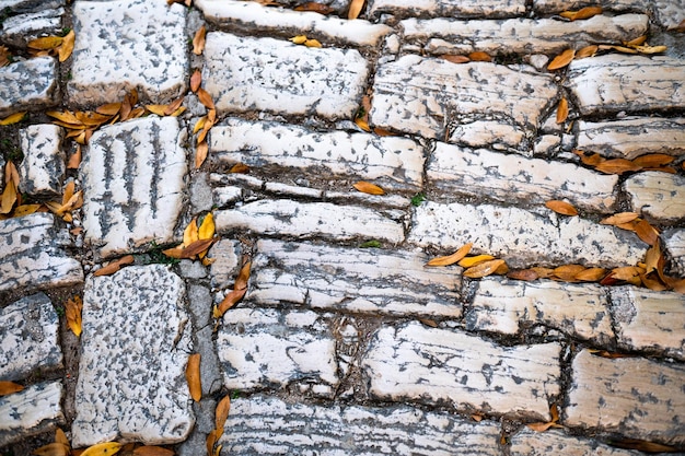 La vecchia pietra strutturata si è schiantata sullo sfondo della parete rocciosa con pori di colore naturale