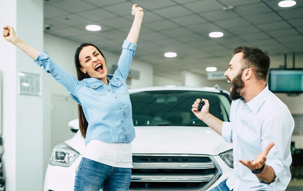 La visita di successo in concessionaria La giovane coppia felice sceglie e acquista una nuova auto per la famiglia