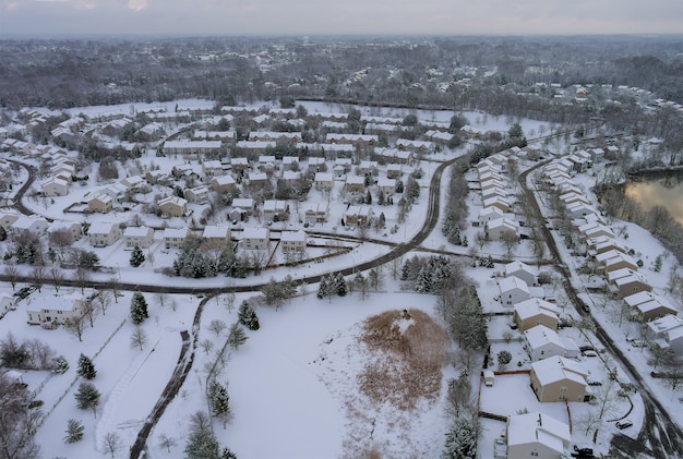 La vista invernale di piccoli cortili complessi di appartamenti case sul tetto sulla neve coperta