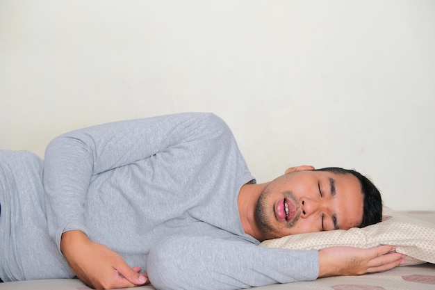 La vista laterale dell'uomo asiatico adulto dorme profondamente