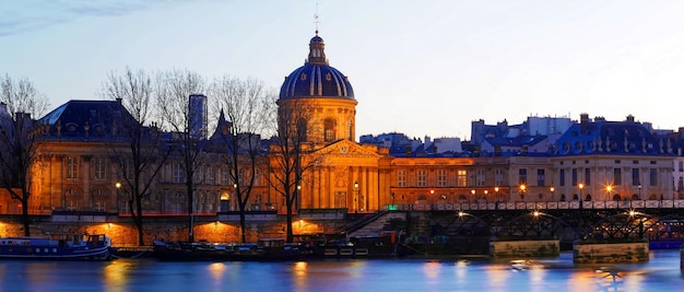 La vista panoramica dell'Accademia francese e del ponte delle arti di notte Parigi Francia