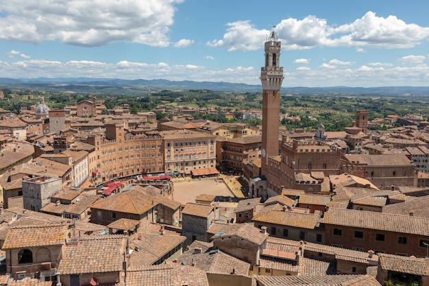 La vista panoramica della città di Siena con Piazza del Campo e la Torre del Mangia è una torre in città dal Duomo di Siena (Duomo di Siena). Giornata di sole estivo e cielo blu drammatico