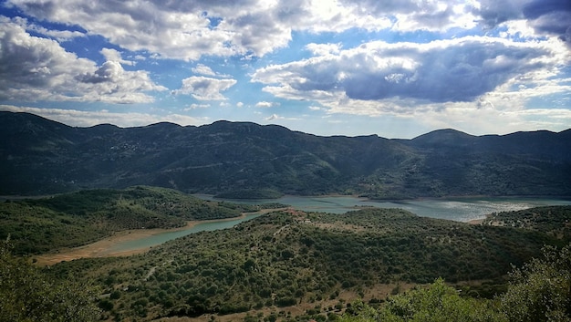 La vista panoramica delle montagne contro un cielo nuvoloso