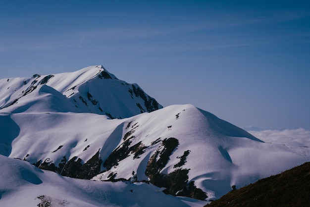 La vista panoramica delle montagne innevate contro il cielo