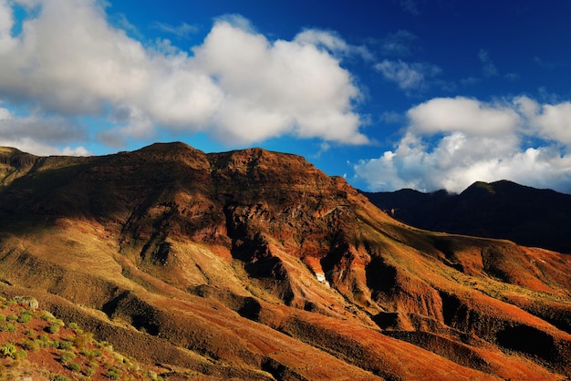 La vista panoramica delle montagne rocciose contro un cielo nuvoloso