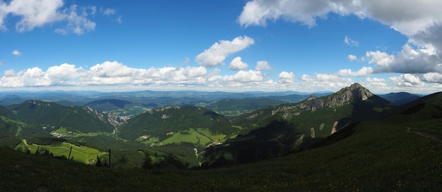 La vista panoramica delle verdi montagne contro un cielo nuvoloso