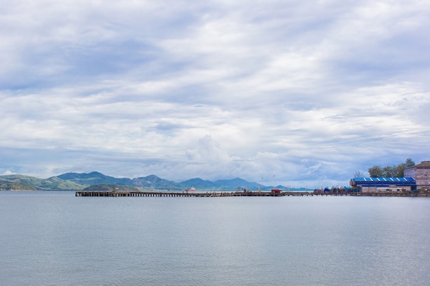 La vista sul mare e sul porto con il cielo è piena di nuvole. C'è una montagna sullo sfondo.