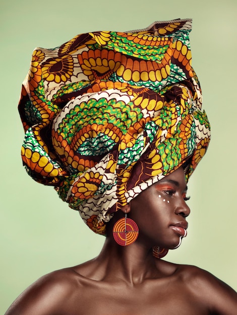 La vita è migliore a colori Foto in studio di una bella giovane donna che indossa un tradizionale copricapo africano su uno sfondo verde