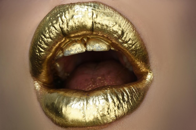 Labbra dorate, lucidalabbra dorato su labbra sexy, bocca aperta metallica. Trucco della donna di bellezza si chiuda.