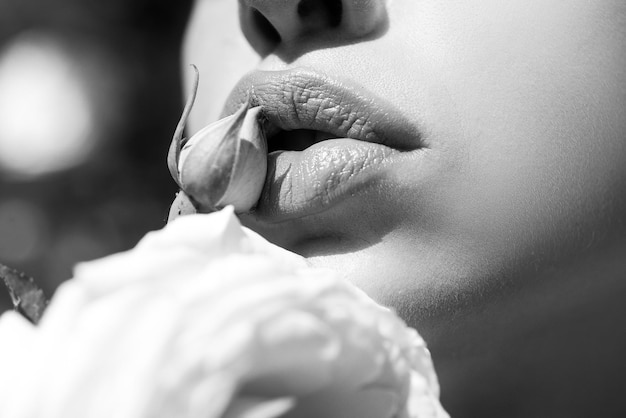 Labbra sexy bellezza labbra rosse trucco dettaglio labbra con fiori primaverili primo piano labbra di bella donna con rosa
