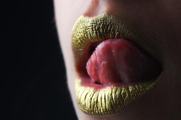 Labbra sexy con la lingua leccante labbra dorate con un creativo rossetto metallico labbro metallico dorato donna sensuale