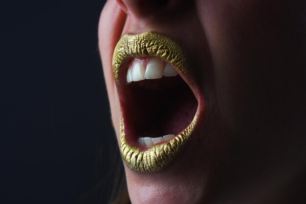 Labbro bocca arrabbiato con effetto scintillio dorato bocca donna primo piano rossetto dorato glamour oro di lusso