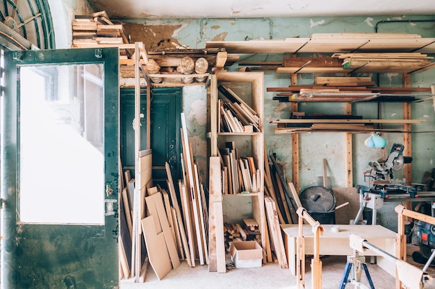 Laboratorio di falegnameria vintage pieno di pezzi di legno e assi di legno