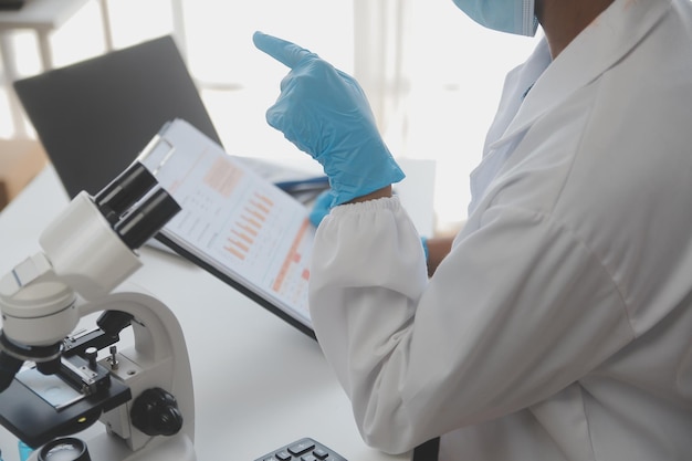 Laboratorio professionale Amazing lavoratore medico dai capelli lunghi che indossa l'uniforme mentre usa il microscopio durante la ricerca