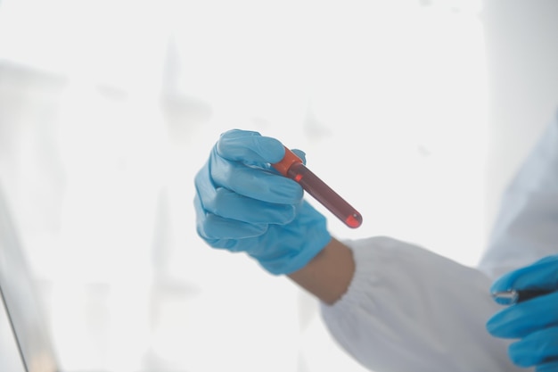 Laboratorio professionale Amazing lavoratore medico dai capelli lunghi che indossa l'uniforme mentre usa il microscopio durante la ricerca